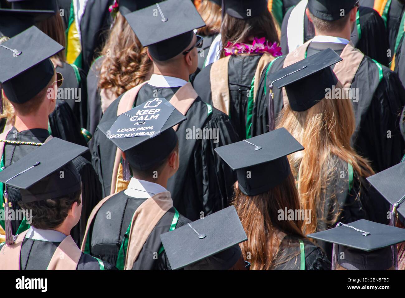 MBA graduation ceremony with cap and gown and a sign Stock Photo