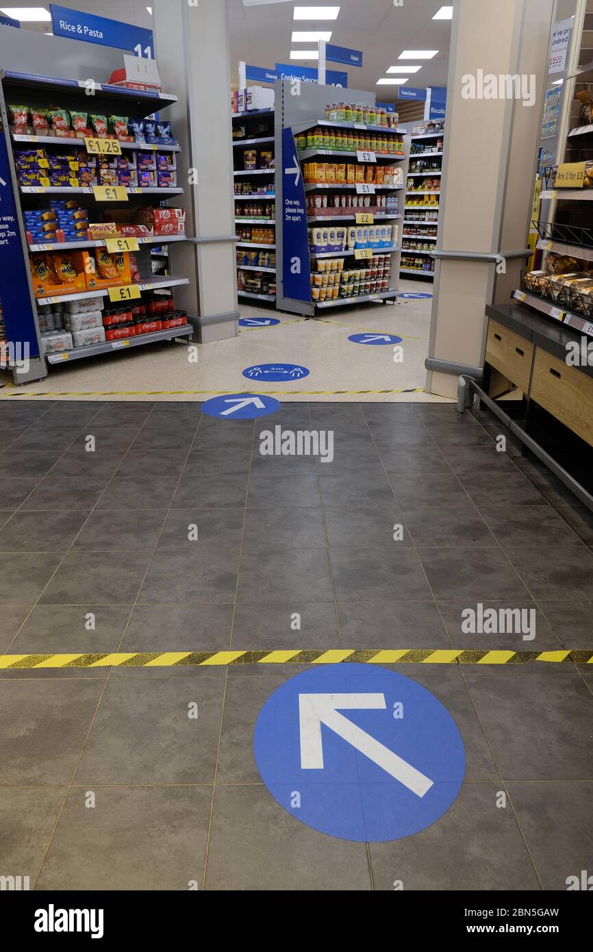 Floor markings and hazard tape mark areas inside a Tesco store in place