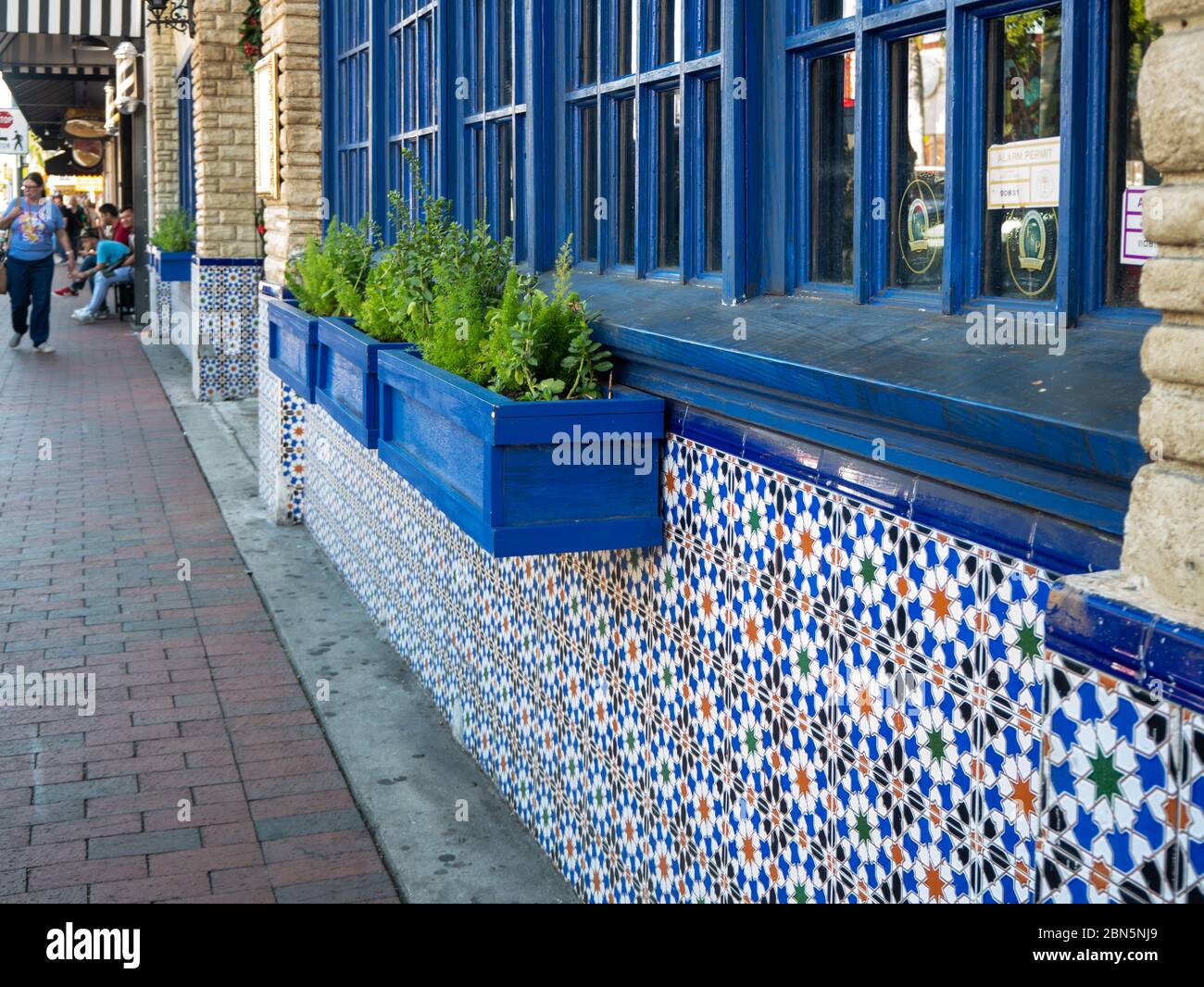 25 November 2019, Miami, Florida Blue paned windows and planter boxes as well as tiled building front along calle ocho in Little Havana, Miami, Florid Stock Photo