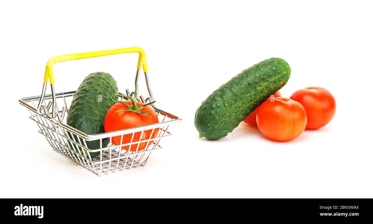 a small shopping basket with vegetables, tomato and cucumber on a white background. Healthy food, vegetarian food, vegetables, shopping at the superma Stock Photo