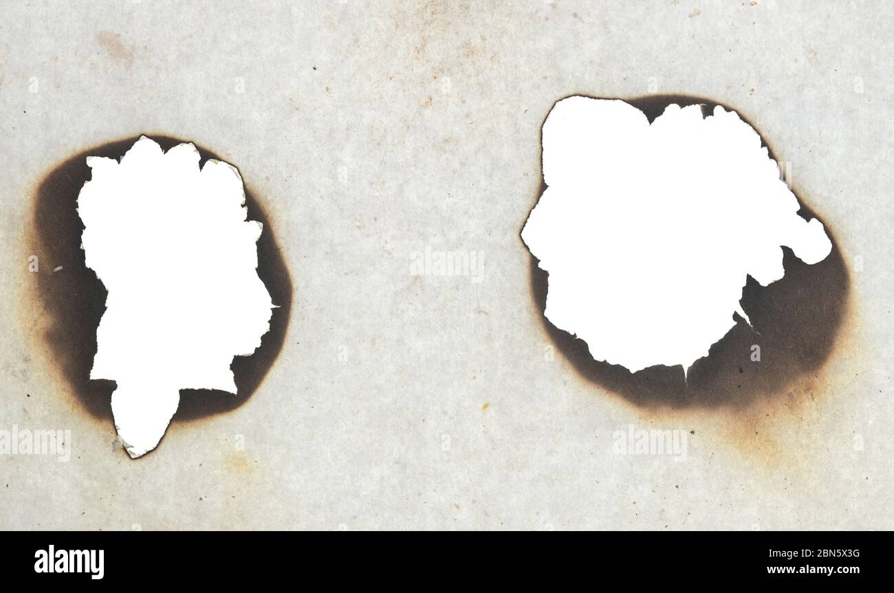 Two burnt holes in a paper Stock Photo Alamy