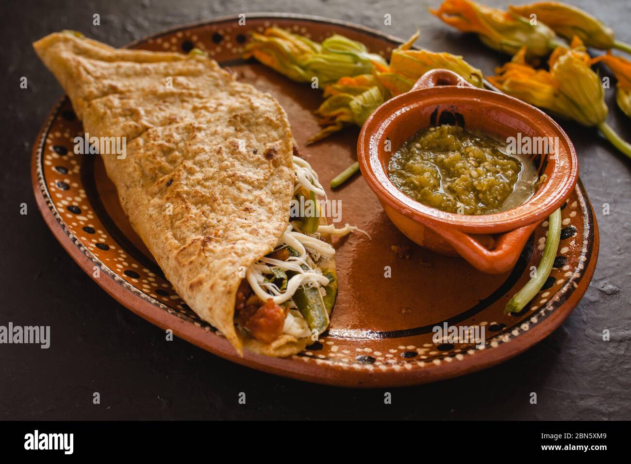 mexican quesadilla with squash blossom, cheese and spicy sauce in