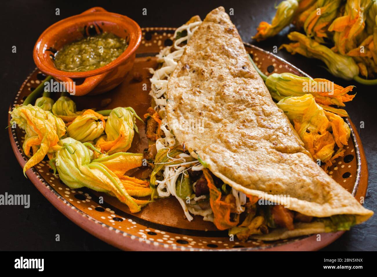 mexican quesadilla with squash blossom, cheese and spicy sauce in