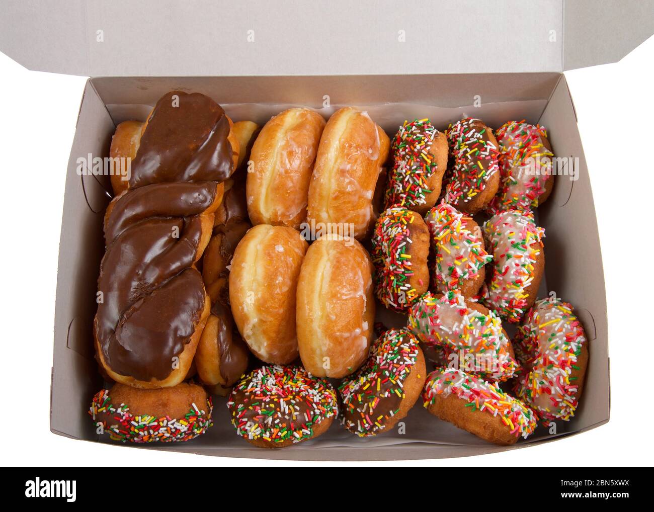 Large box with various donuts. Cake with sprinkles, glazed and chocolate covered twists, and basic glazed donuts. A popular american junk food. Stock Photo