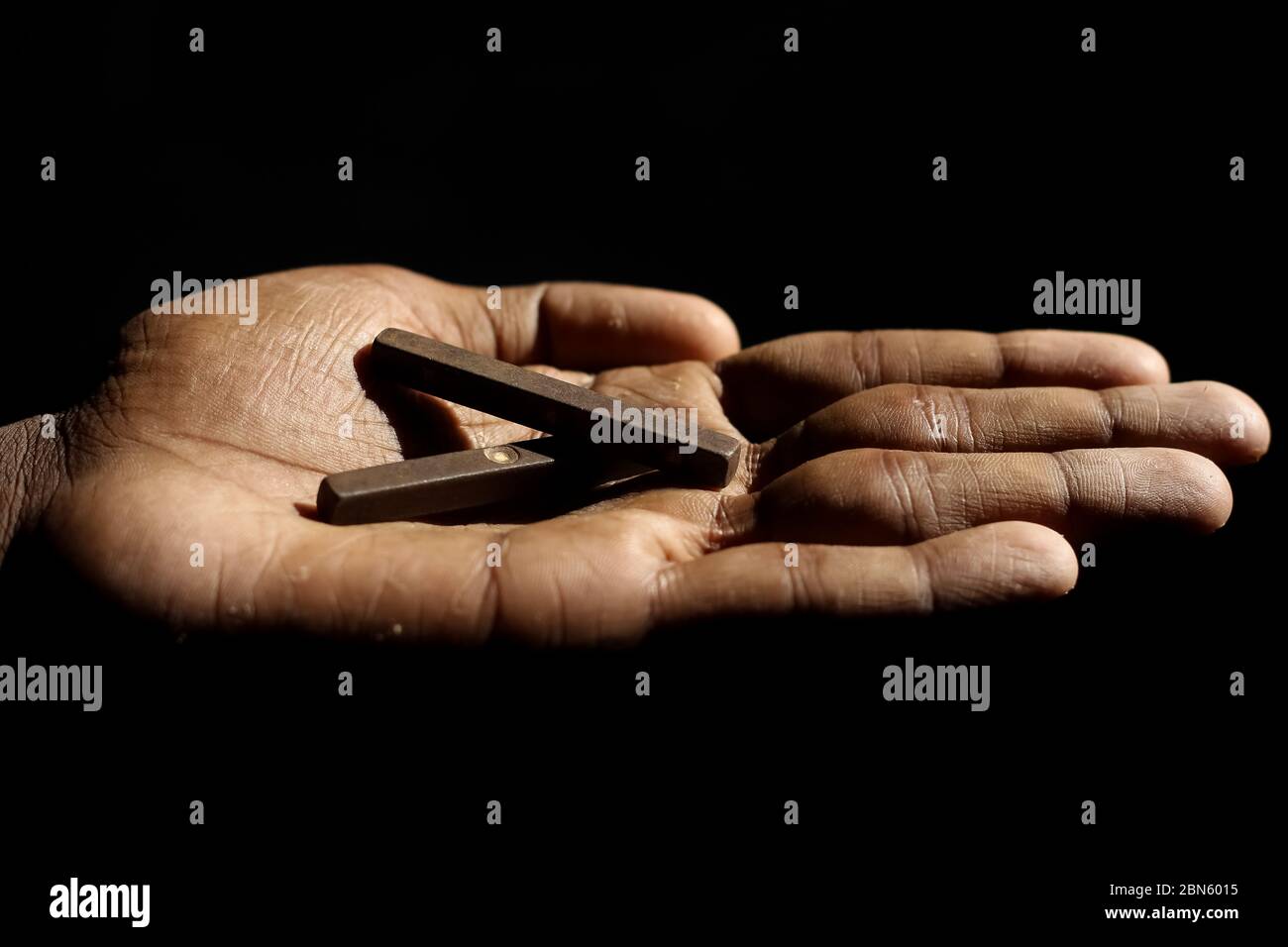 Antique Indian copper Long / Stick Dices with 1-2-5-6 to the 4 long sides holding on Hand isolated on black background. Indian Four Sided Ludo game di Stock Photo