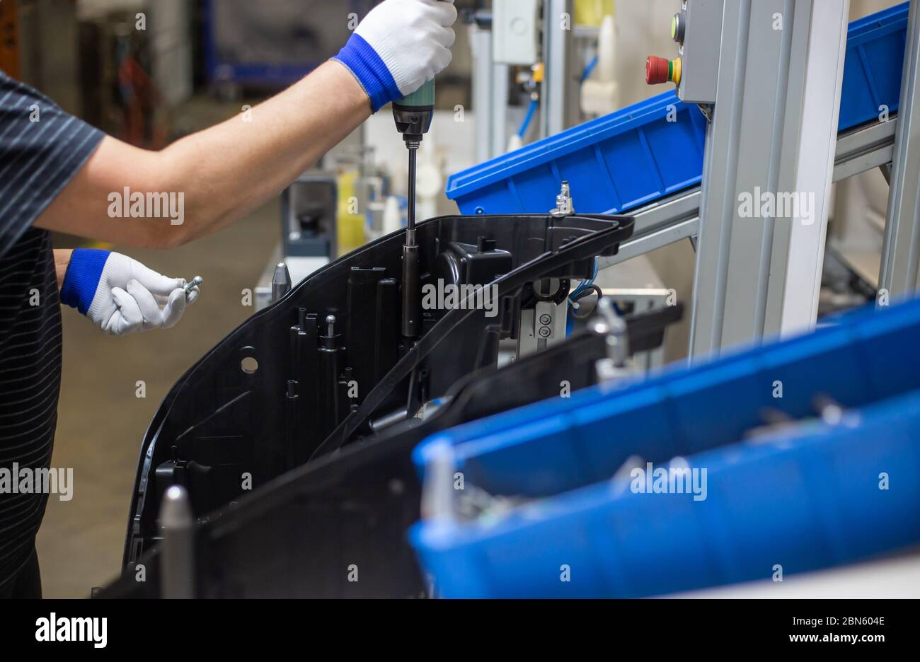 Production operator assembling frontlight headlamp, headlight for a vehicle or a car in automotive industry Stock Photo