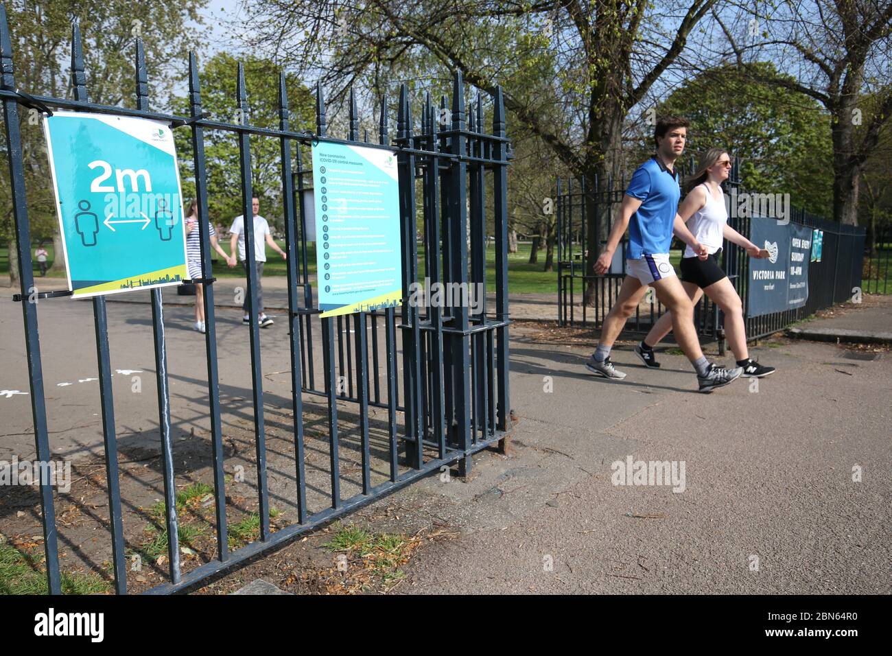 Signs on the gates reminding people to 'social-distance' at Victoria Park in east London. Park rangers and security will 'step in' if social distancing measures are ignored at open spaces, the boss of London's Olympic Park has warned as restrictions on outdoor activities are eased. Stock Photo