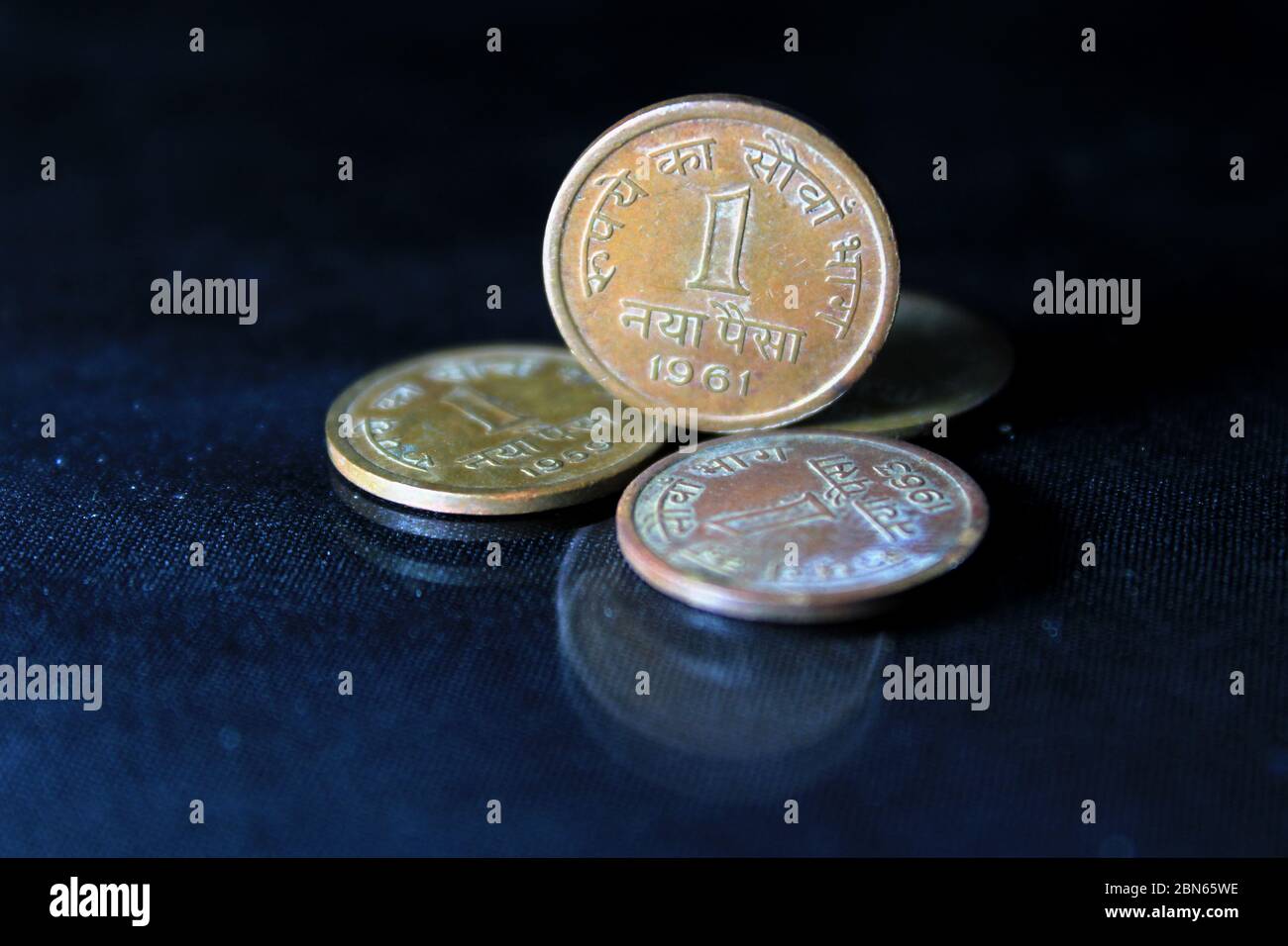 An old Indian one paisa coins isolated on a black background. A closeup picture of one naiya paise coins 1959, 1961, 1963. Stock Photo