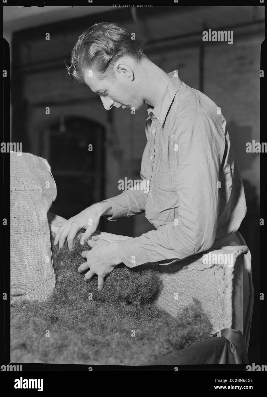 Applying filling (hair) in arm of sofa, 1936 by The U.S. National