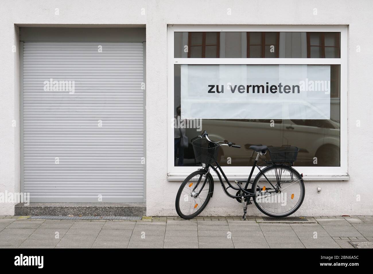 German vacancy sign in store window - zu vermieten translates as for rent or to let - bicycle parked outside closed shop Stock Photo
