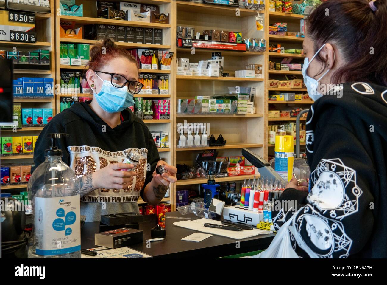 Cincinnati, United States. 12th May, 2020. Cincinnati, Ohio. May 12 2020: Lefty's  Tobacco employee Courtney Blagg assists a customer as Ohio businesses  reopen in the wake of the Coronavirus COVID-19 pandemic, Tuesday,