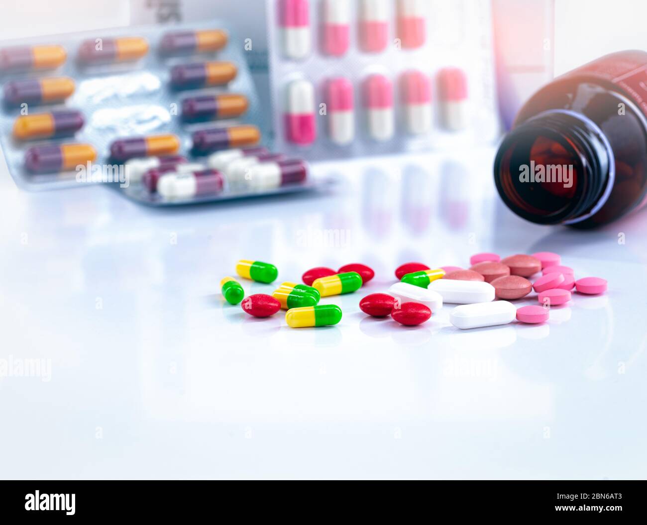 Colorful tablets and capsule pills on blurred background of drug bottle and antibiotic capsule pills. Pharmaceutical industry. Background for content Stock Photo
