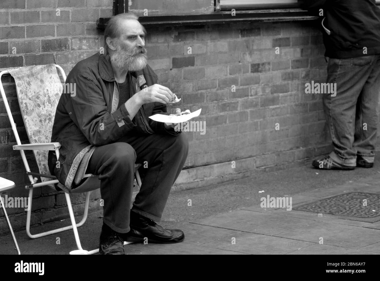 Old man eating on the street, Darlington, County Durham Stock Photo