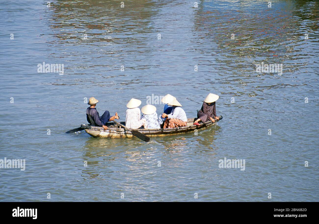 Vietnam: A leg rower transports a group of women across the harbour in Nha Trang, Khanh Hoa Province.  Nha Trang is a coastal city and capital of Khan Stock Photo
