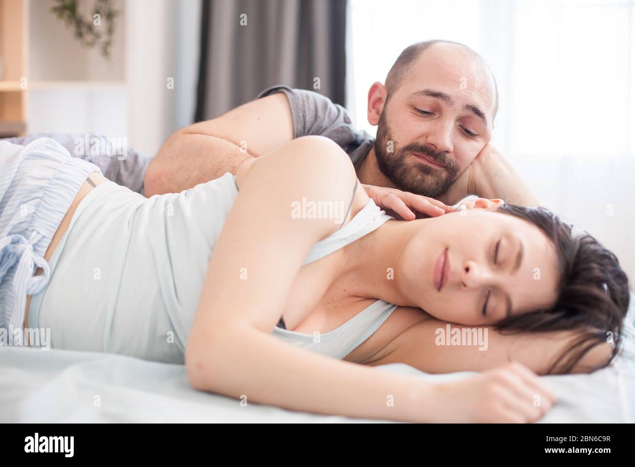 Husband in the morning looking how his wife is sleeping