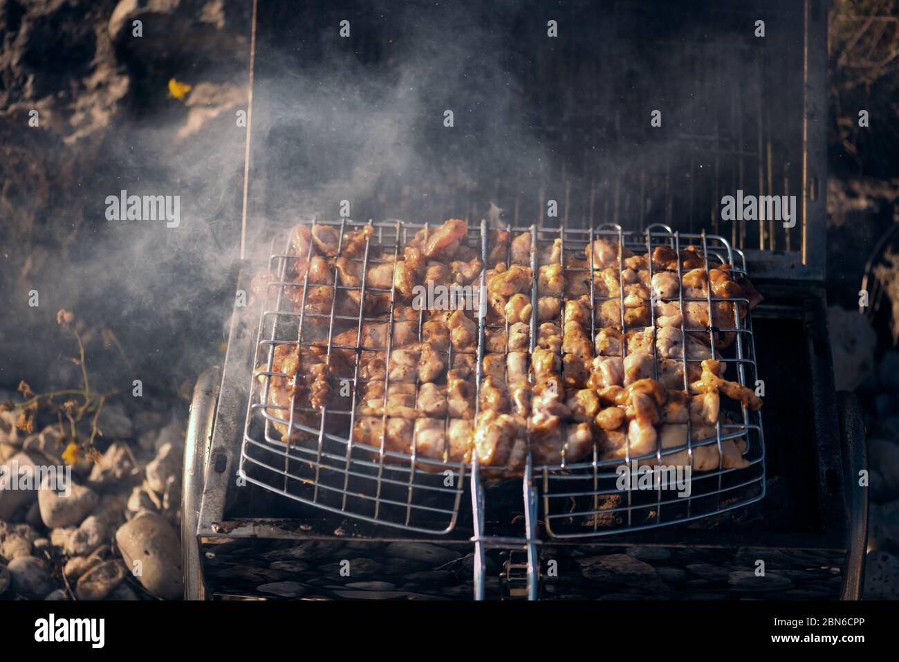 Grilled meat with smoke outdoors cooking in portable barbeque Stock ...
