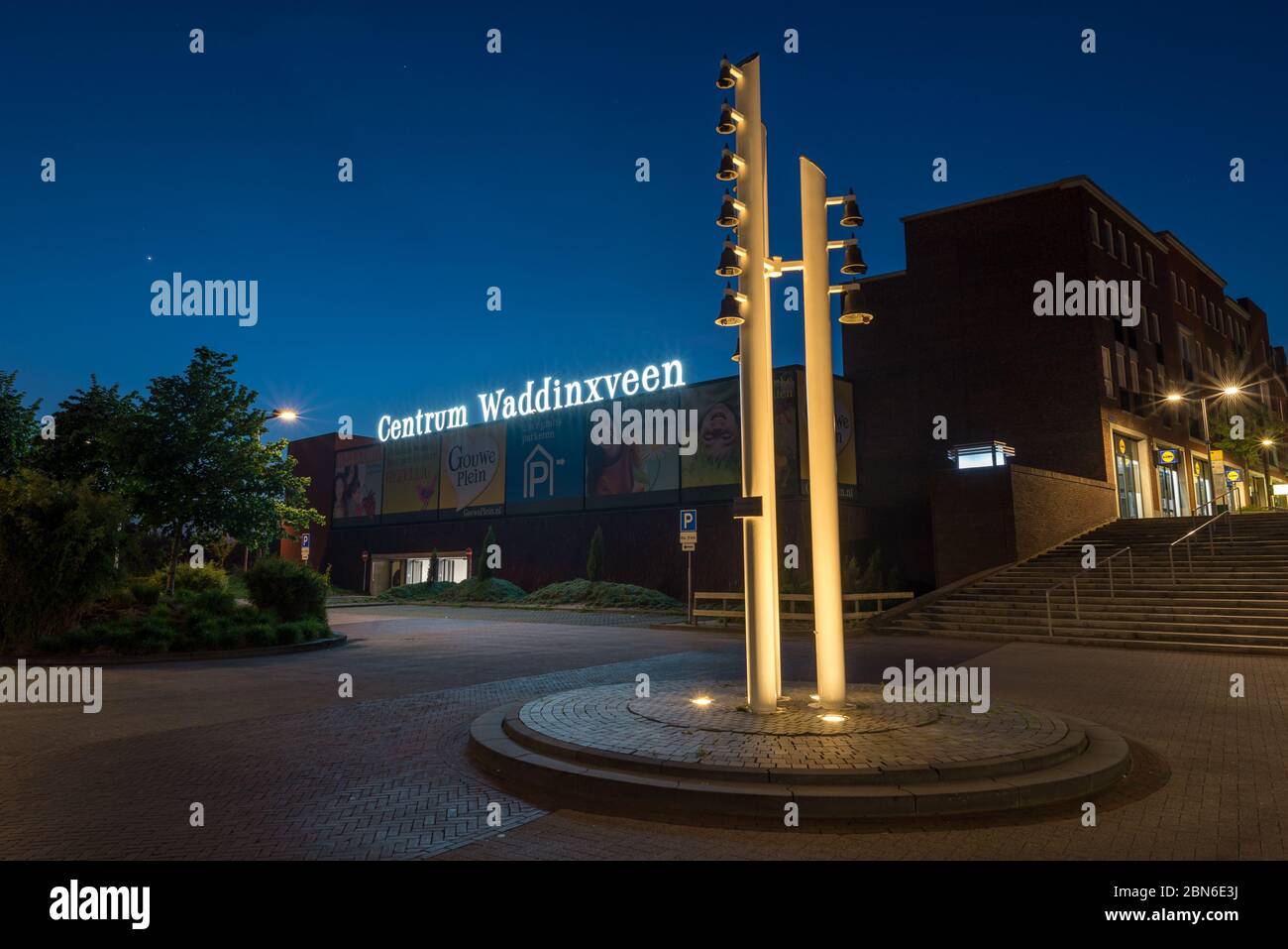 Entrance of modern centre of the town of Waddinxveen, Netherlands at night. Traditional chimes or carillon in the foreground. Stock Photo