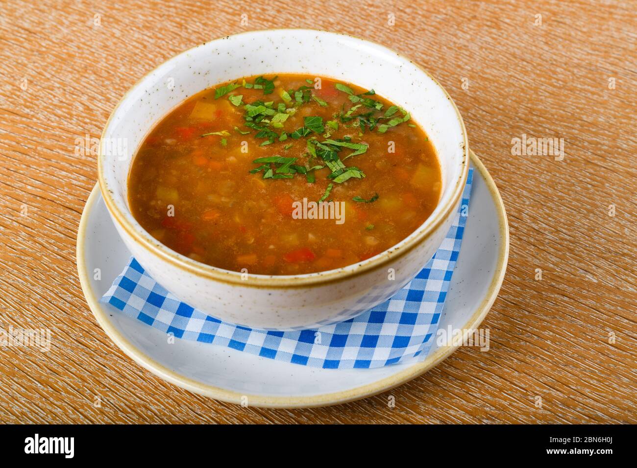 Fresh lentil soup in a white bowl, served in a restaurant setting