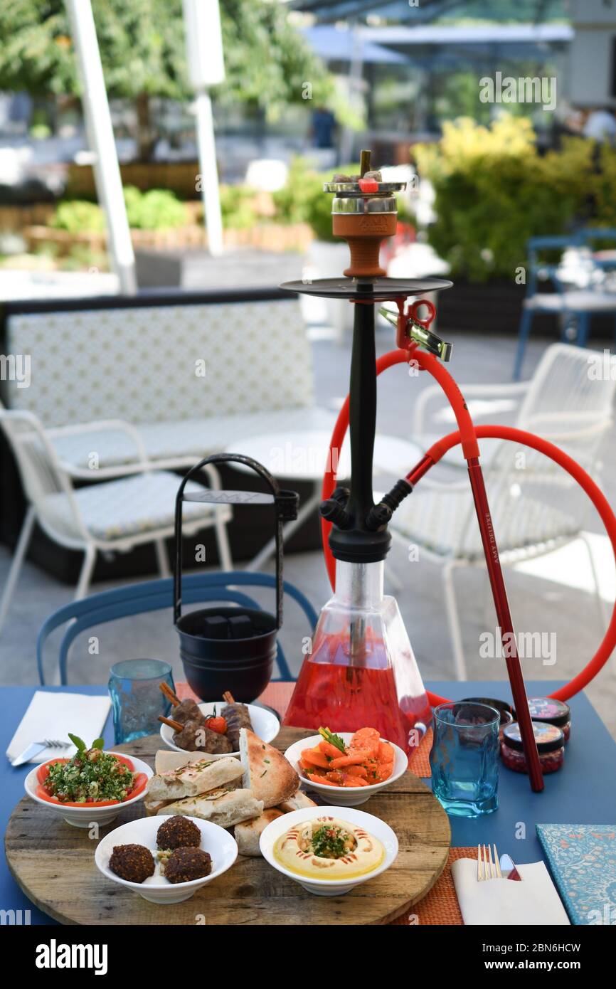 Shisha hookah on restaurant table in the garden. Metal hookah on a summer  terrace with a blurred background Stock Photo - Alamy