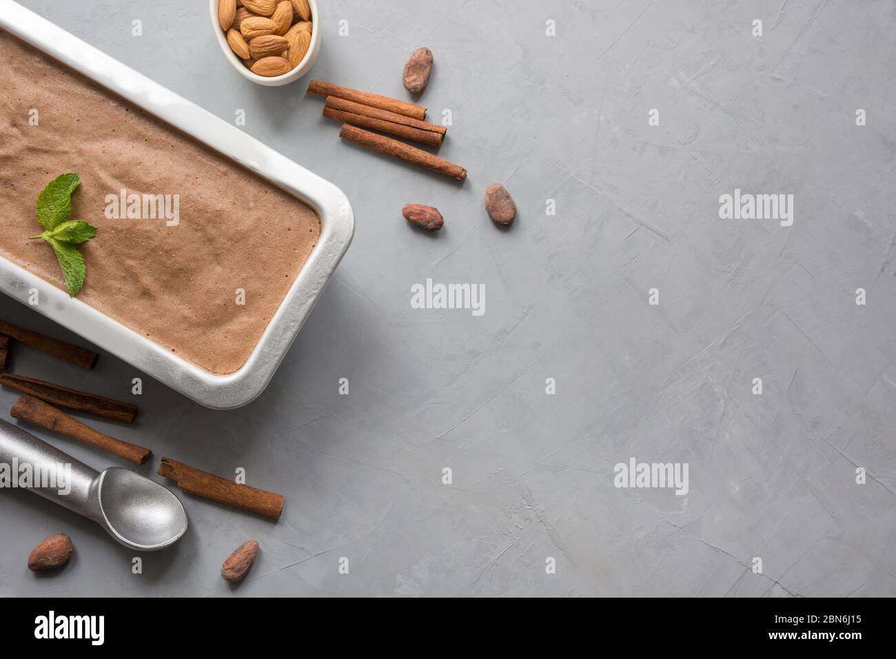 Banana chocolate homemade ice cream with coffee beans and almond on grey background. Space for text. View from above. Stock Photo