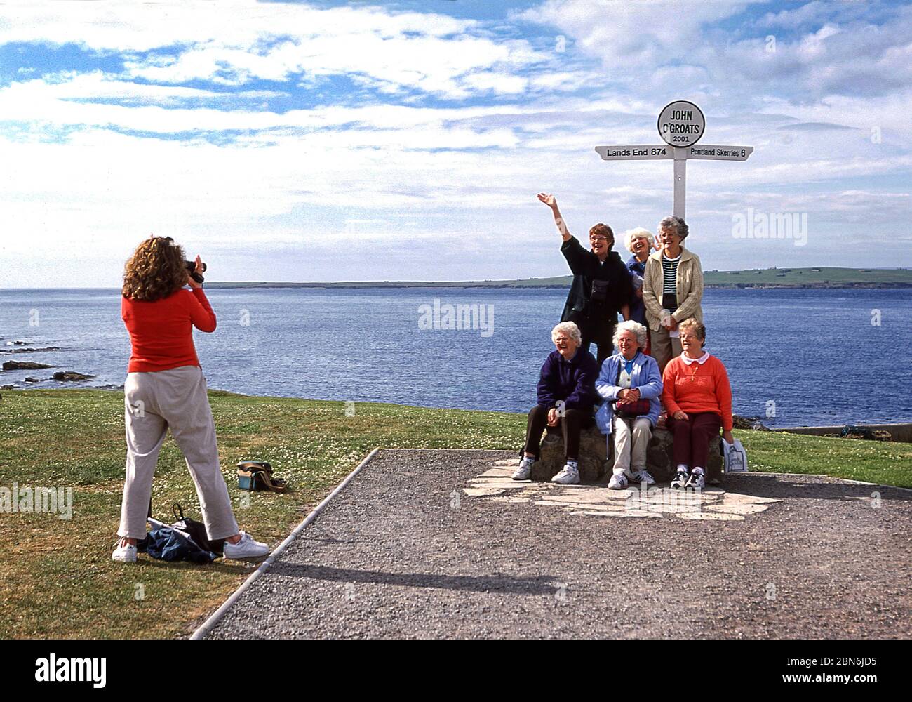 Group of tourists at the John O' Groats signpost. a stop on the North Coast 500 route in the Scottish highlands Stock Photo