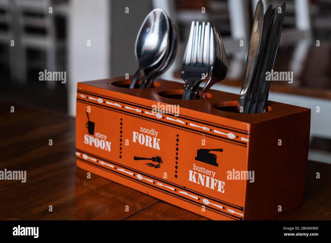 Stand with knives, forks and spoons in cafe on table Stock Photo