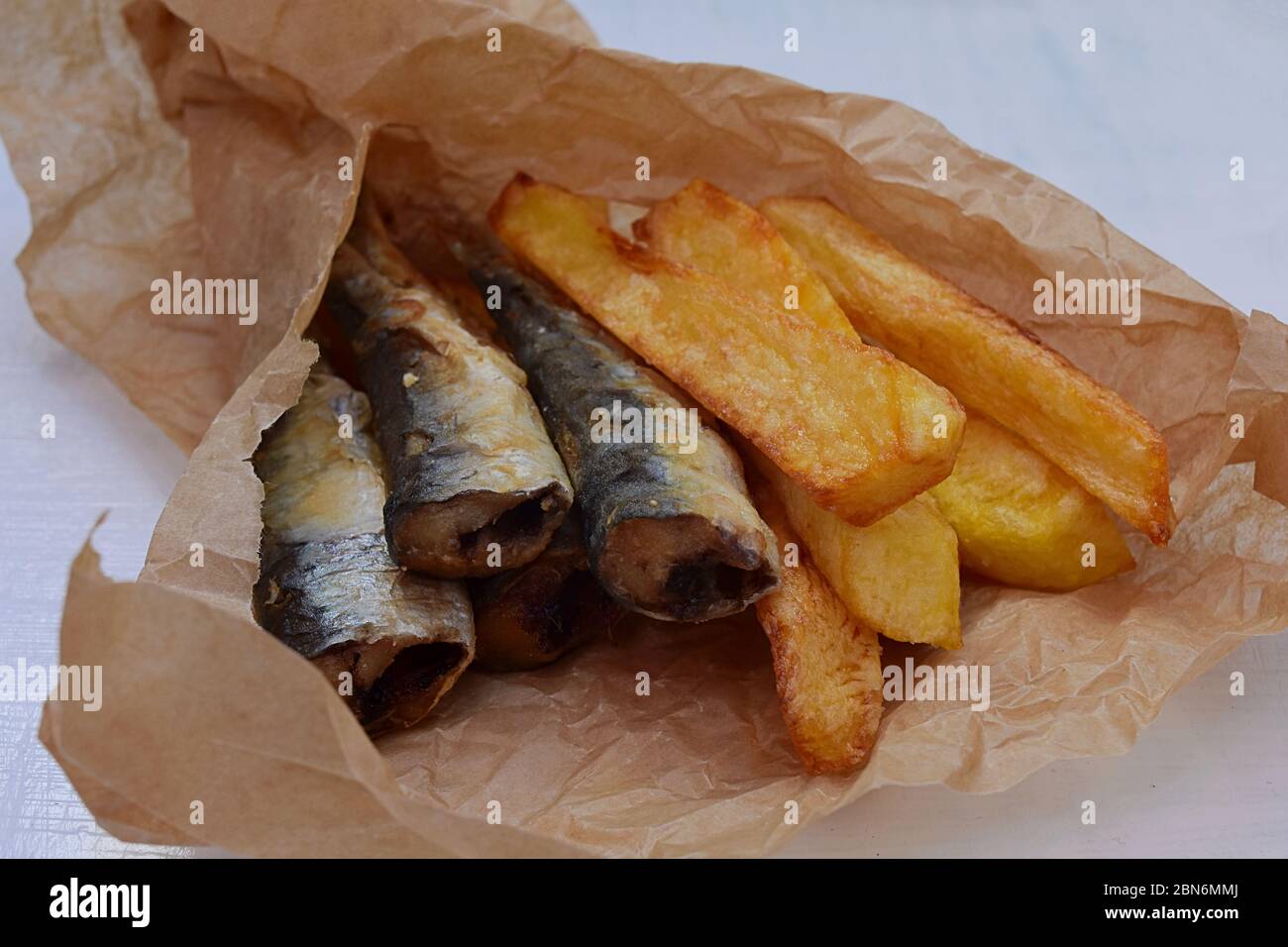 Fish and chips in a paper wrapper/ Yummy takeaway food/ Classic British fish and chips/ fast food Stock Photo