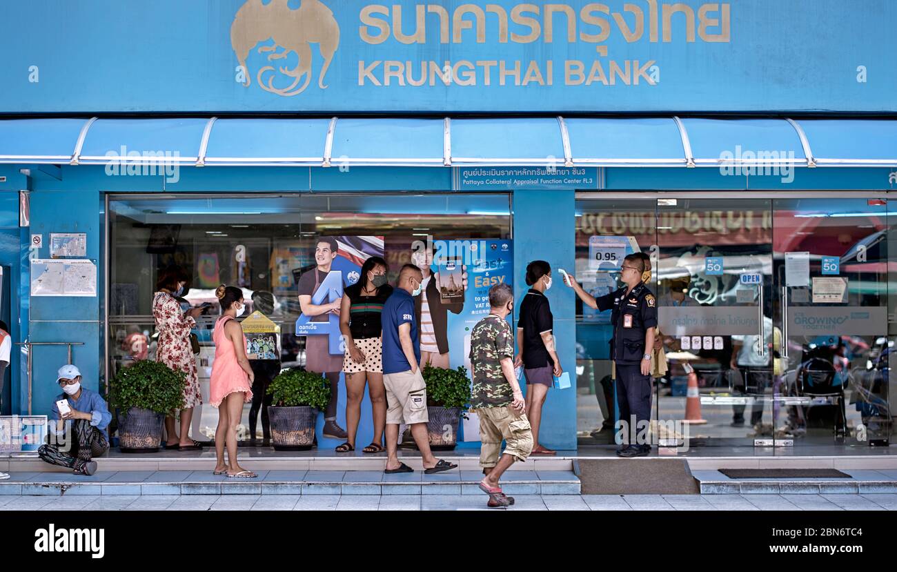Covid -19 temperature check and social distancing applied to customers queueing at a Thailand bank. Coronavirus discipline Stock Photo