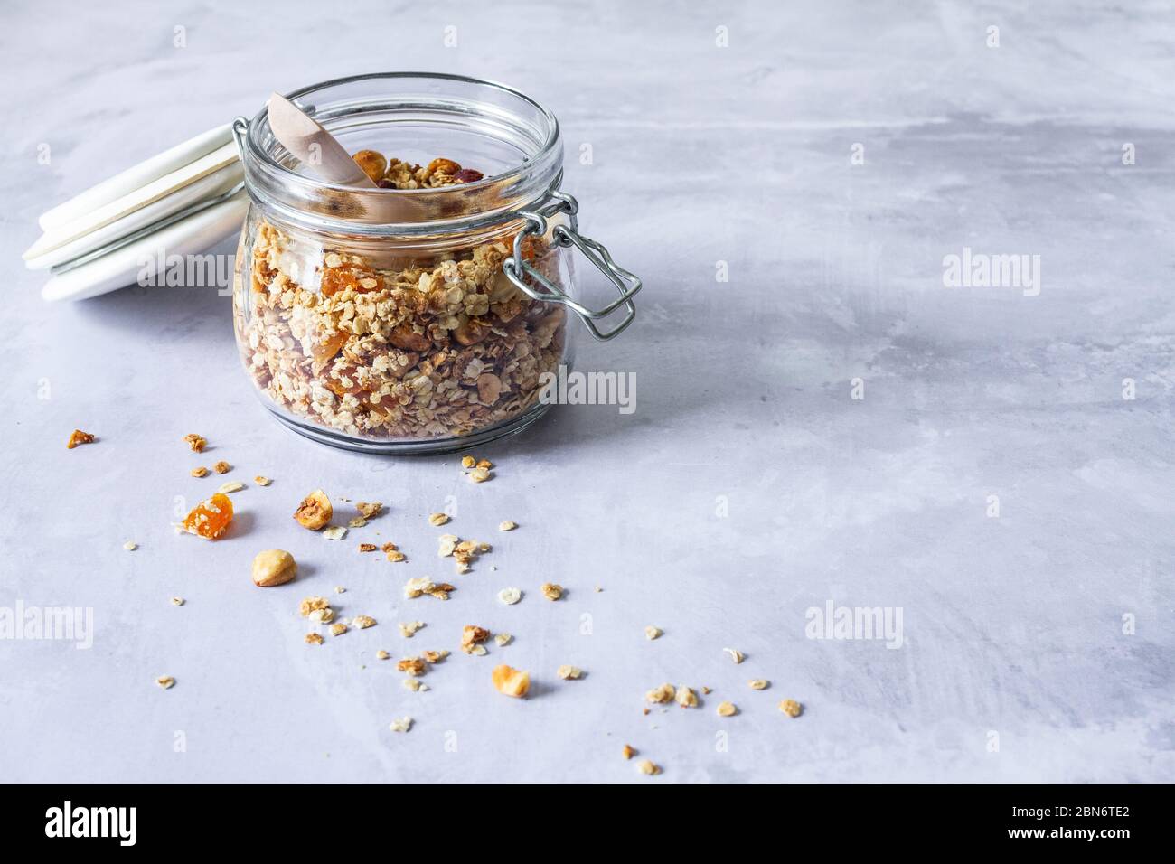 Jar of homemade apricot and hazelnut granola on a concrete backdrop Stock Photo