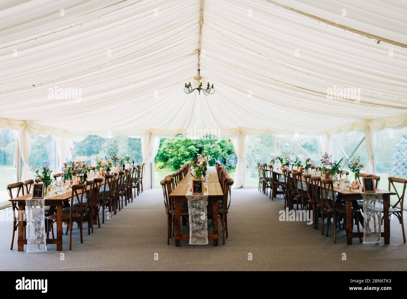 an empty wedding marquee set up and decorated in a rustic style ready for the wedding breakfast. English outdoor wedding Stock Photo