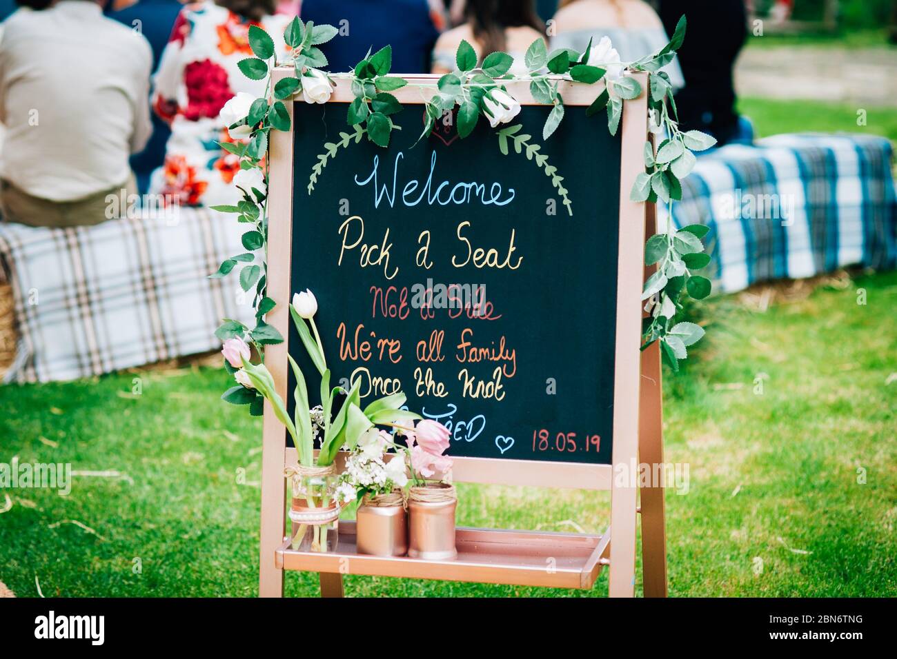 A rustic blackboard welcome sign at an english outdoor farm wedding ceremony Stock Photo