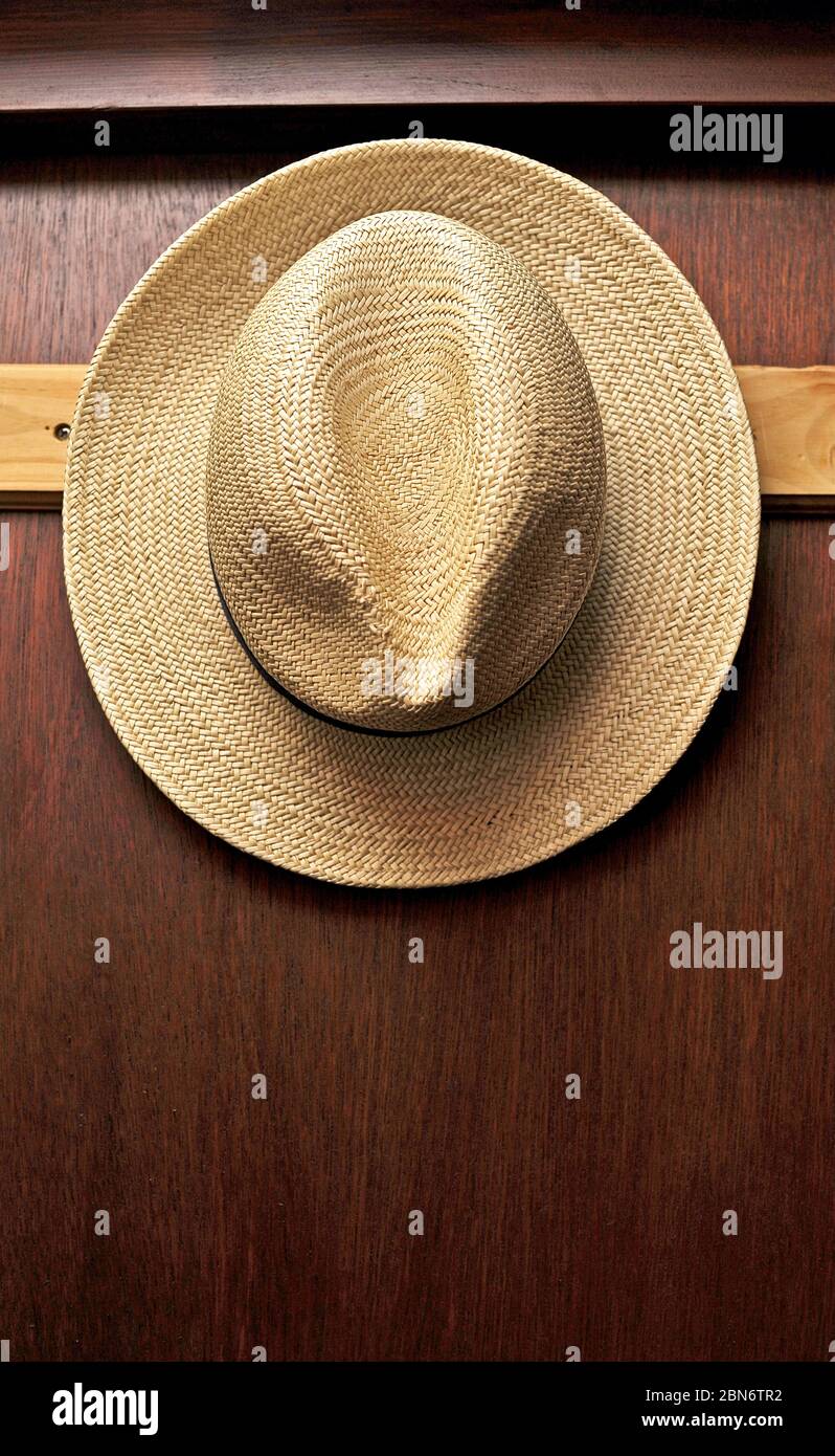 Straw hat hanging on hook on door Stock Photo Alamy