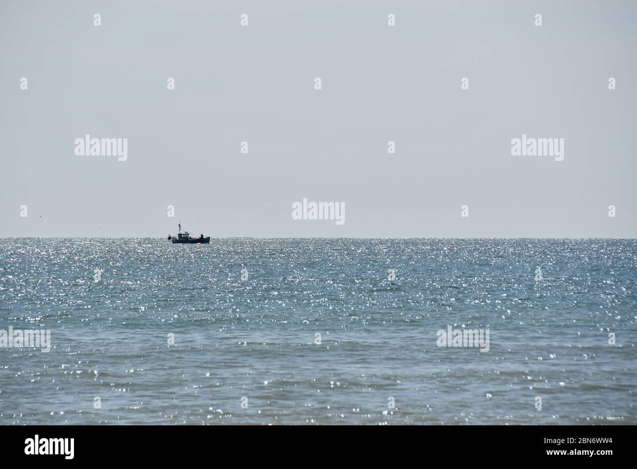 Single fishing boat at sea on a sunny day Stock Photo