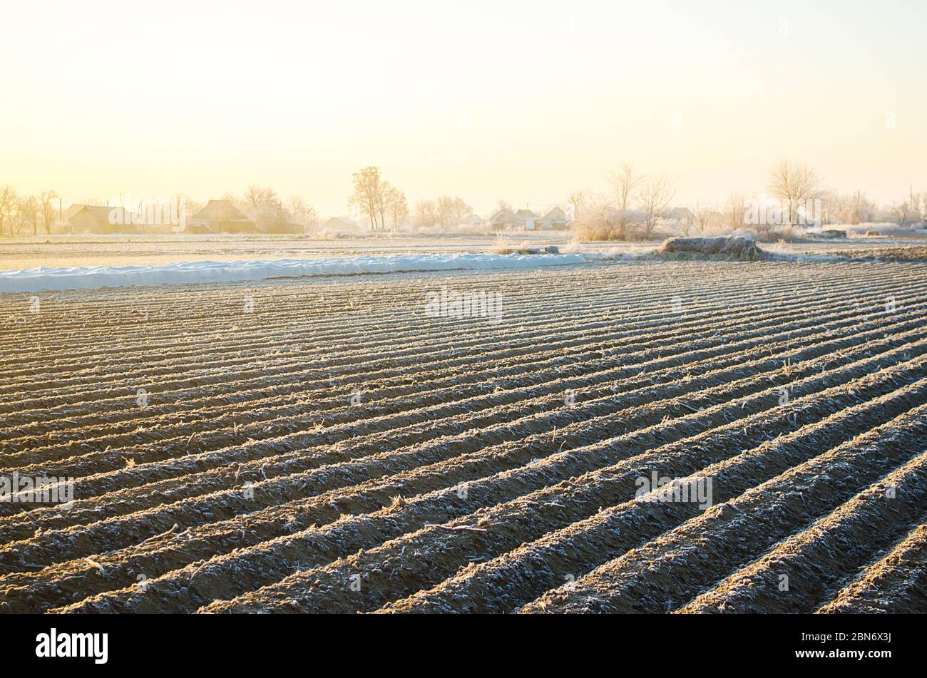 Winter farm field ready for new planting season. Preparatory agricultural work for spring. Choosing right time for sow fields plant seeds, protection Stock Photo