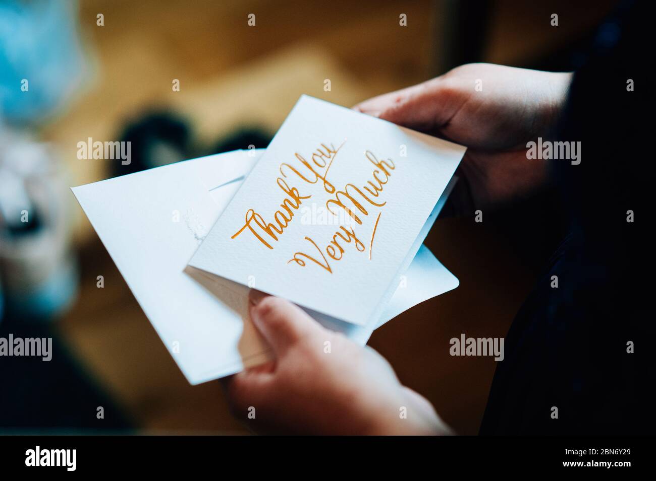 a person holding a thank you card with the words thank you very much written on it Stock Photo