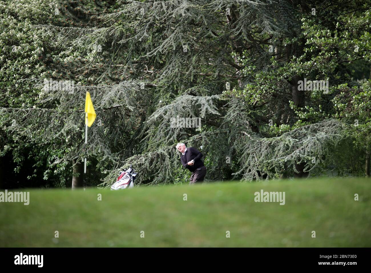 Day Fifty One of Lockdown, in Peterborough. A person is able to get back to playing golf, here at Orton Meadows golf Course, in Peterborough. Today is the first slight relaxing of lockdown in England as the message from the government is now 'stay alert' instead of 'stay at home'. Is is now possible to play golf, go fishing, and garden centres can open too, but social distancing measures should be maintained. The country has been on lockdown due to the COVID-19 Coronavirus pandemic. COVID-19 Coronavirus lockdown, Peterborough, UK, on May 13, 2020 Stock Photo