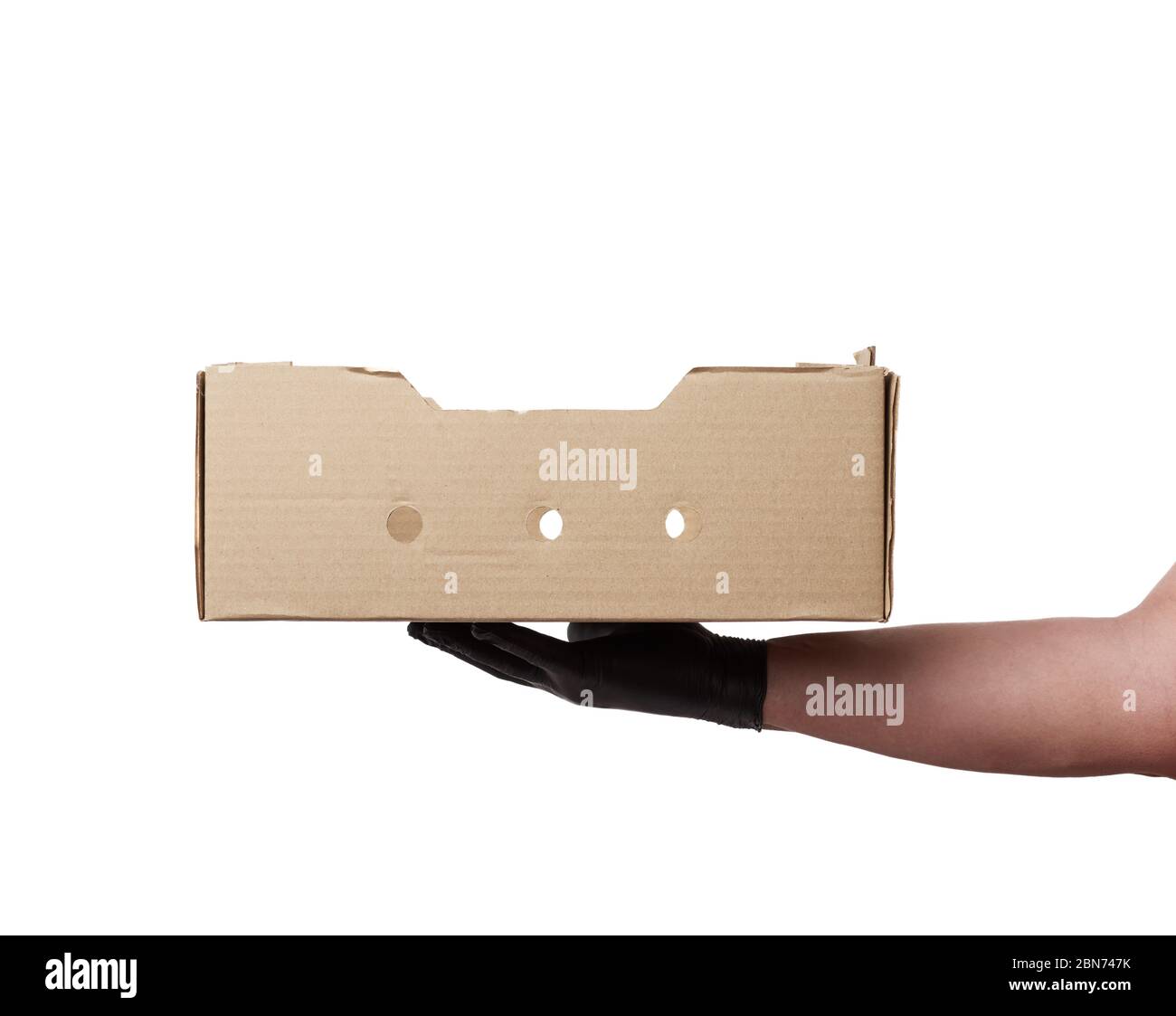 male hand in a black latex glove holds an empty brown cardboard box on ...