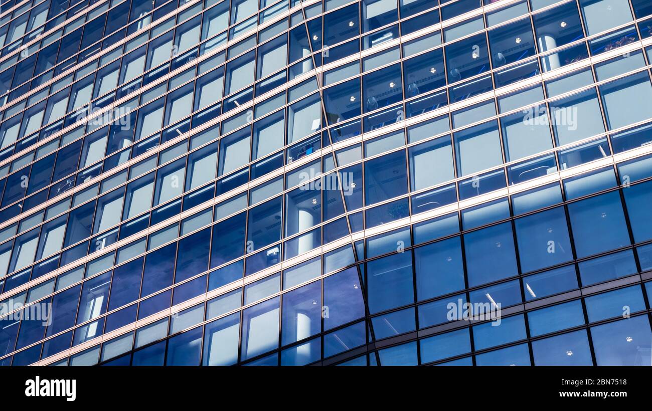 Blue Business Building. An angular and abstract full frame view of the windows to a generic contemporary office building. Stock Photo