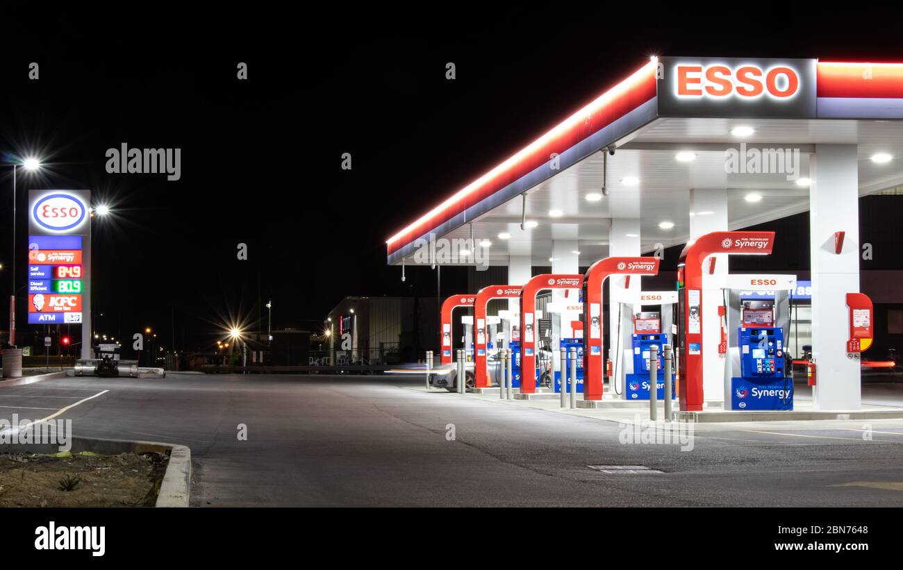New Esso gas station seen late at night as few vehicles fill up at the gas pumps. Stock Photo