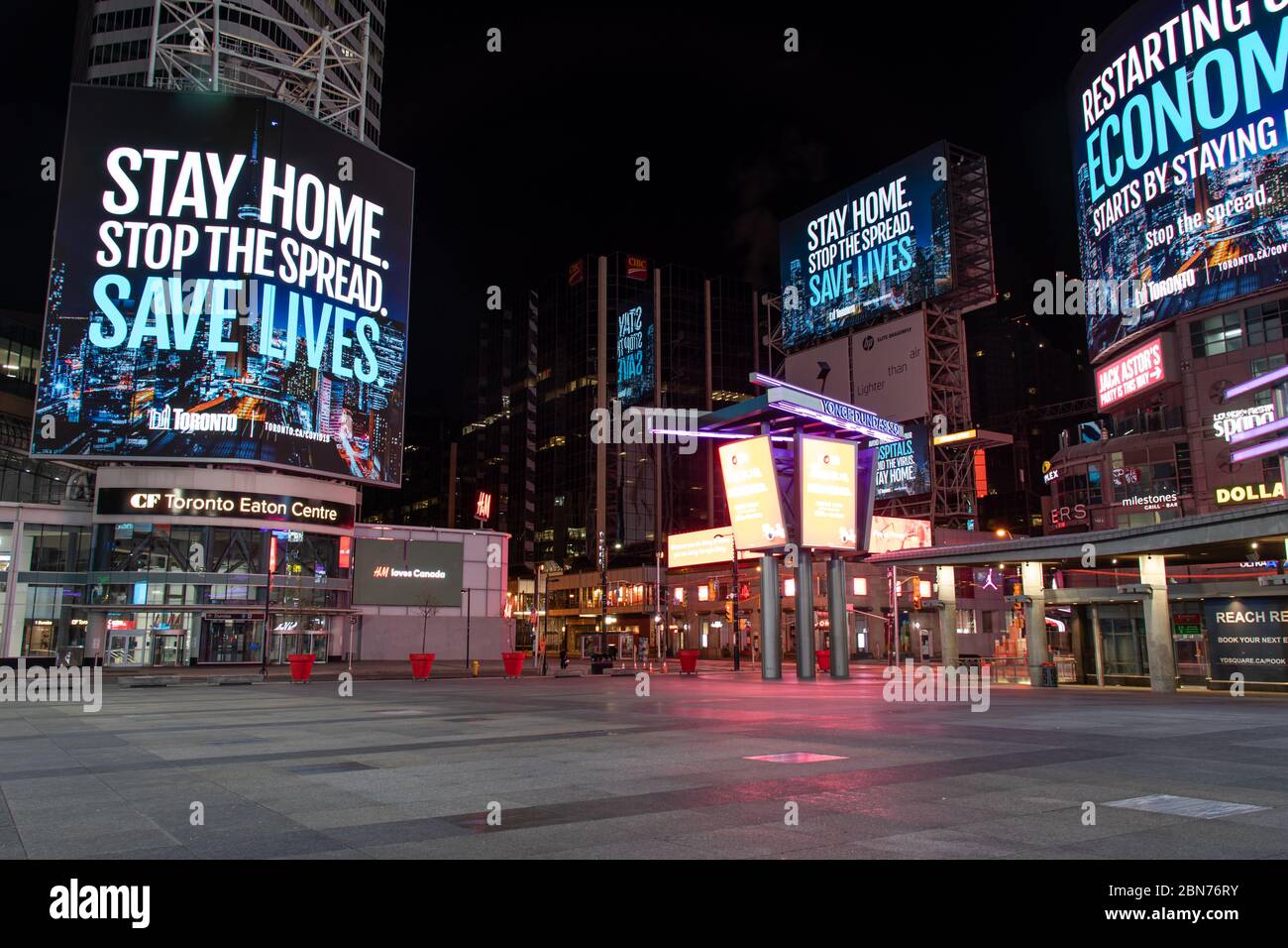 Toronto’s Young-Dundas Square empty at empty, with digital billboards reading “Stay home. Stop the spread. Save lives.” during the COVID-19 pandemic. Stock Photo