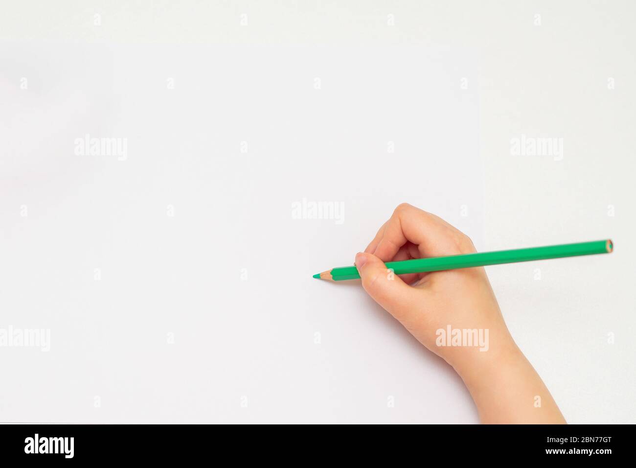 Top view of baby's hand drawing with green pencil on white paper with the  set of colour pencils. Kids painting concept. Copy space for text. Mockup  Stock Photo - Alamy
