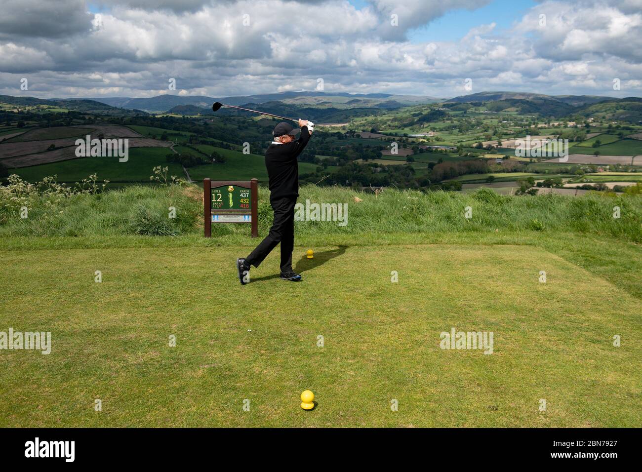 A player tees off at the scenic 12th hole at Llanymynech Golf Club, Oswestry, where the course crosses the border of England and Wales. The course faces uncertainty as lockdown restrictions on golf are lifted in England from today, but remain in force in Wales. Stock Photo
