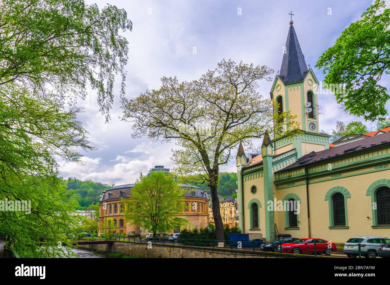 Karlovy Vary, Czech Republic, May 11, 2019: St. Peter and Paul church and Kaiserbad Spa Imperial Bath or Lazne I, Tepla river embankment in Carlsbad historical city centre, West Bohemia Stock Photo