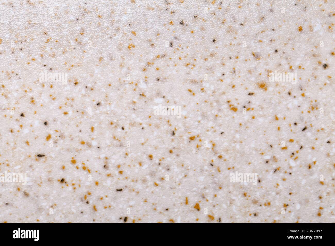Grainy beige background with yellow and white spots. Texture backdrop