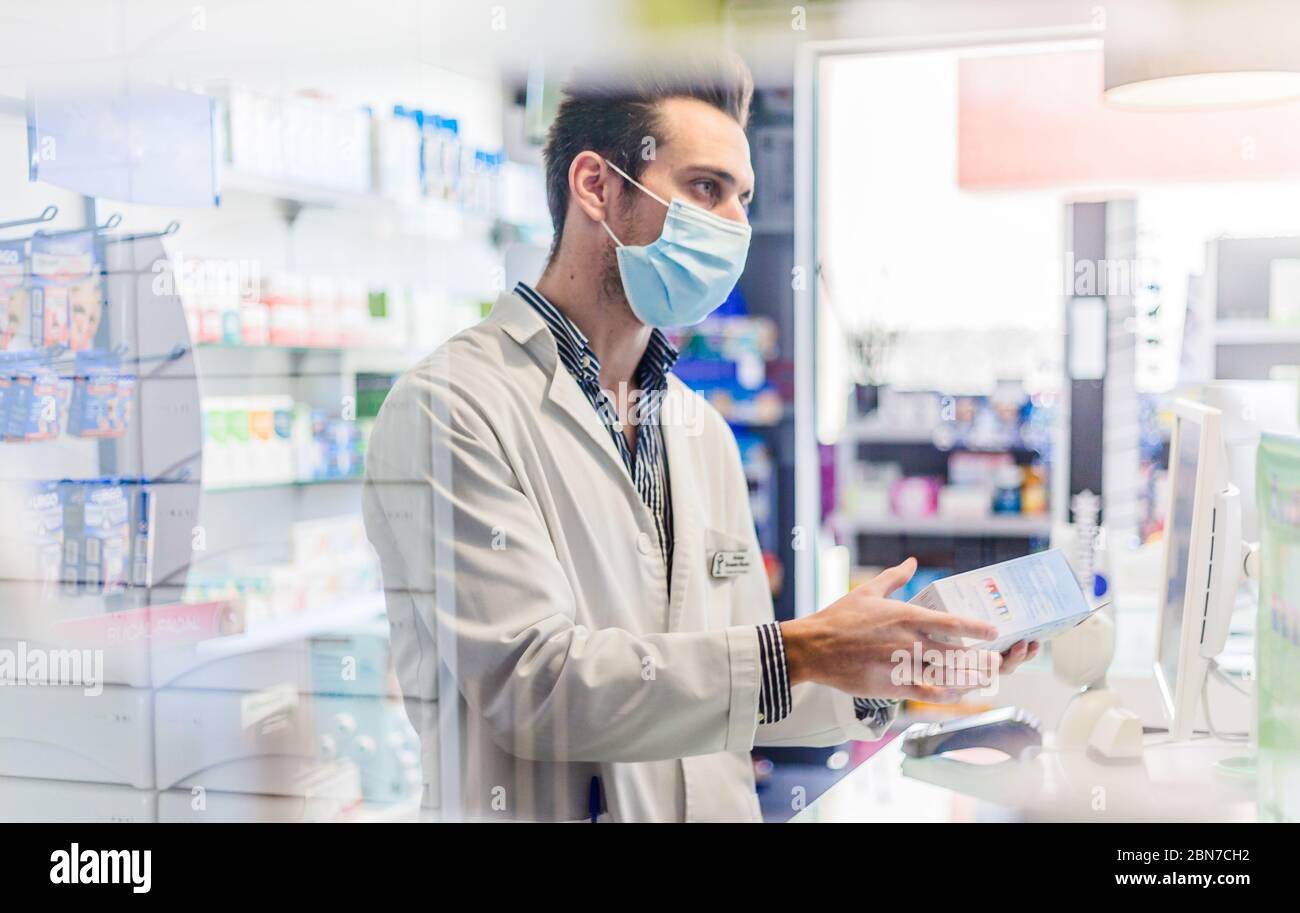 Pharmacist attending patients using a face mask Stock Photo