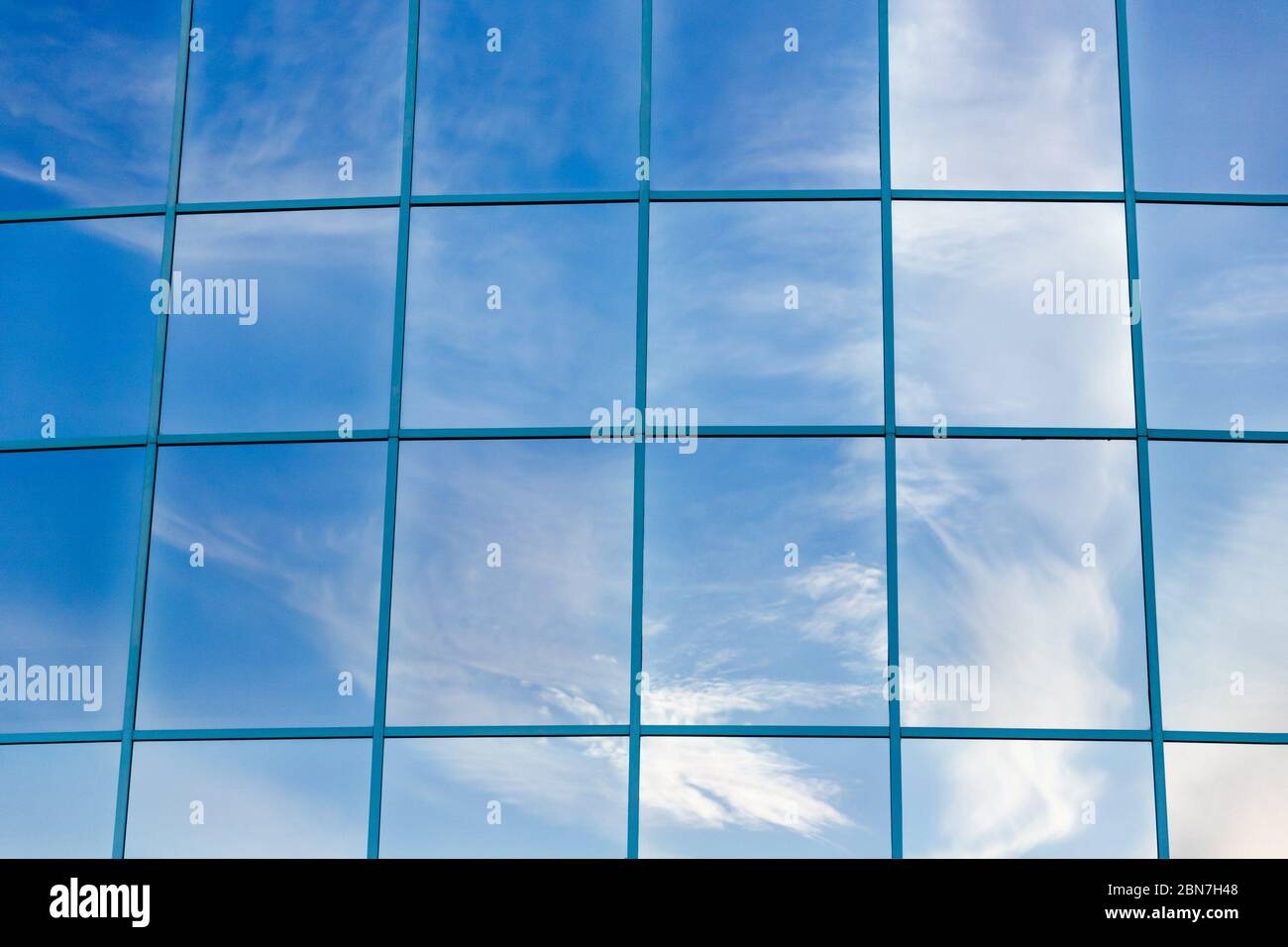 Reflection of blue sky with white clouds in glass facades of modern ...