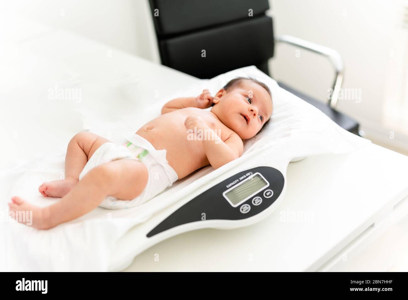 https://c8.alamy.com/comp/2BN7HHF/close-up-of-a-doctor-checking-weight-of-cute-little-baby-healthcare-concept-2BN7HHF.jpg