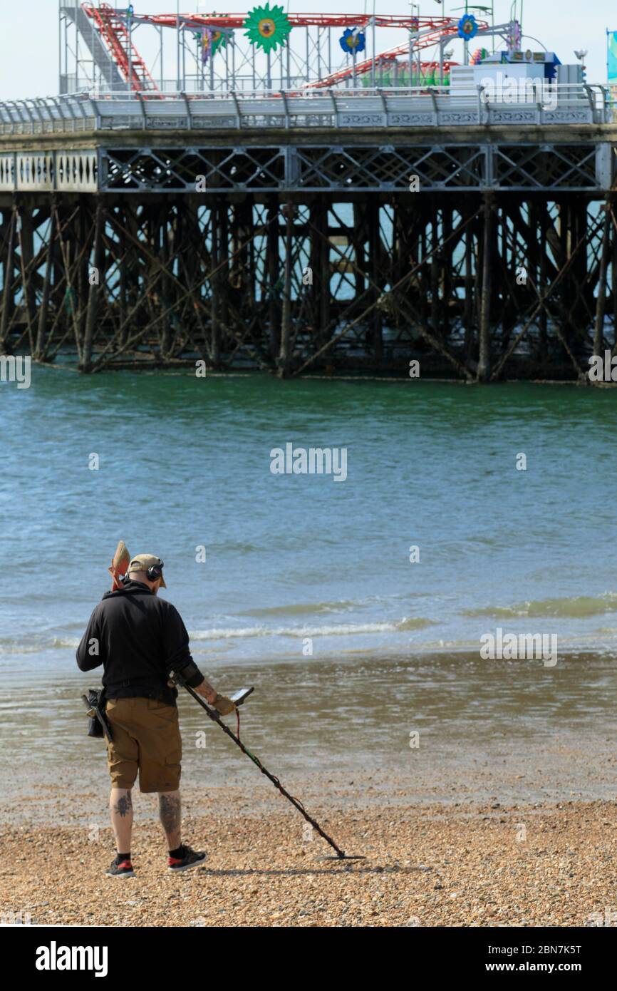Portsmouth, UK. 13th May, 2020. A metal detectors searches the beach taking advantage of the new more relaxed lockdown rules, at Southsea, near Portsmouth, UK Wednesday May 12, 2020 Photograph Credit: Luke MacGregor/Alamy Live News Stock Photo