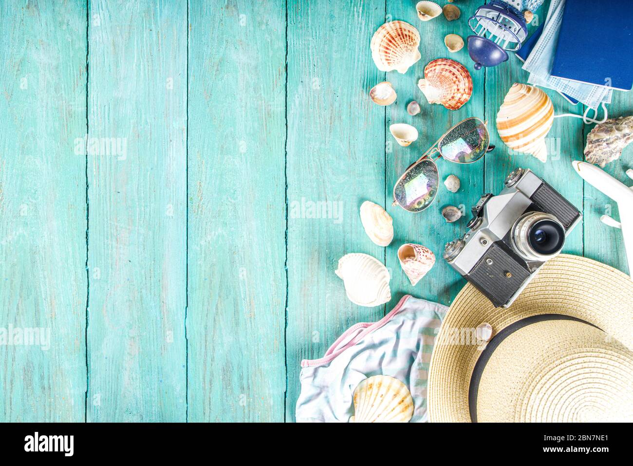 Bright  summer flat-lay background. Old blue wooden background with with summer woman clothes, sun glasses, hat, camera, passports and vacation ticket Stock Photo