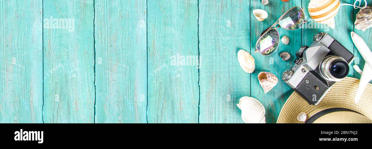 Bright  summer flat-lay background. Old blue wooden background with with summer woman clothes, sun glasses, hat, camera, passports and vacation ticket Stock Photo